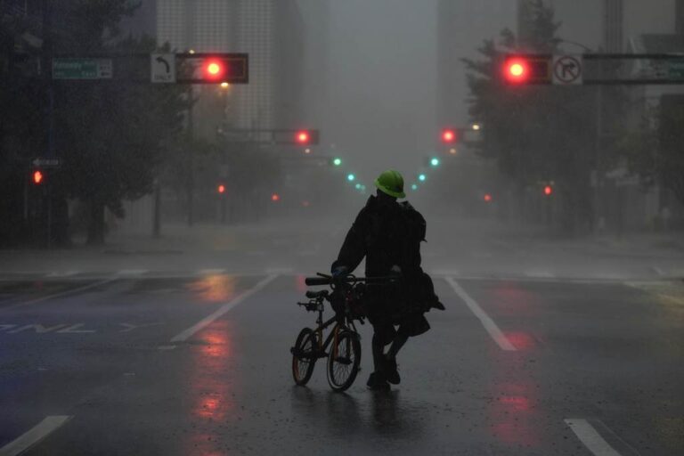 Ron Rook, who said he was looking for people who might need his help or debris to remove, walks in the rain and wind in the desert central Tampa before Hurricane Milton makes landfall in Florida on Oct. 9, 2024.